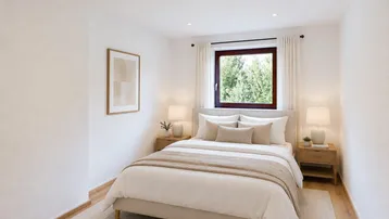 Helles Schlafzimmer mit Holzboden, großem Fenster und Blick ins Grüne, modern eingerichtet.