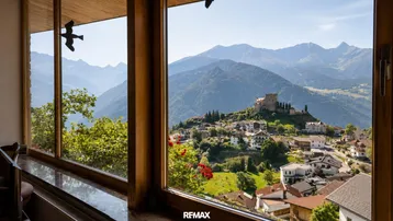 Große Fenster bieten einen atemberaubenden Blick auf die umliegende Berglandschaft und ein malerisches Dorf.