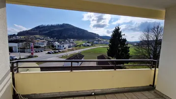 Geräumiger Balkon mit weitem Blick auf die umliegende Landschaft und Berge.