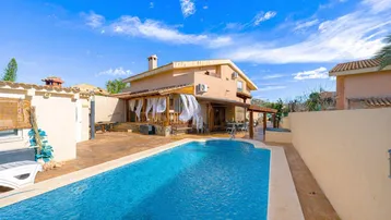 Großzügiger Außenbereich mit privatem Pool und sonniger Terrasse, ideal für Entspannung und Unterhaltung.
