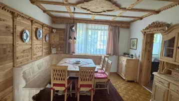 Gemütlicher Essbereich im alpinen Stil mit Holztäfelung, Eckbank und Parkettboden.