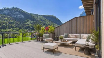 Große möblierte Terrasse mit bequemen Sitzgelegenheiten und atemberaubendem Bergblick.