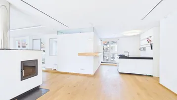 Heller, offener Wohnbereich mit modernem Kamin und Parkettboden, ideal für geselliges Beisammensein.