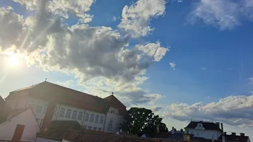 Malerischer Ausblick über Dächer und historische Gebäude unter einem weiten Himmel.