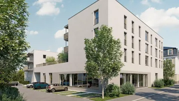 Moderne Wohnanlage mit heller Fassade, großen Fenstern und Außenparkplätzen an der Straße.