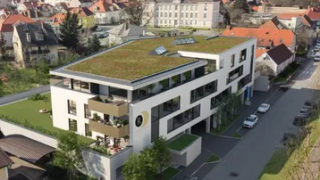 Moderne Wohnanlage mit Gründach, großzügigen Balkonen und Blick über die Stadt.