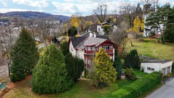 Historische Villa mit weitläufigem Grundstück und Blick auf die umliegende Landschaft im Herbst.
