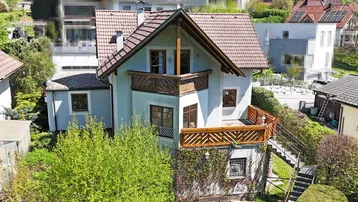 Vogelperspektive des Hauses mit Balkonen und Terrassen in grüner Umgebung.