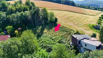 Luftaufnahme eines Grundstücks mit umliegenden Feldern, Wäldern und einem Haus mit Solaranlage.