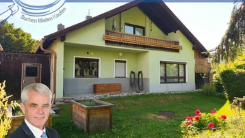Hausfassade mit Gartenbereich und gepflegter Grünfläche, umgeben von Bäumen und Sträuchern.