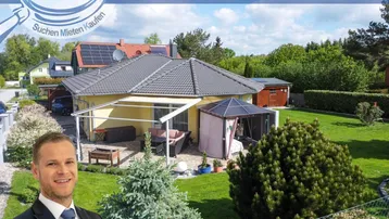 Ansicht des Hauses von außen mit gepflegtem Garten, überdachter Terrasse und Gartenlaube.