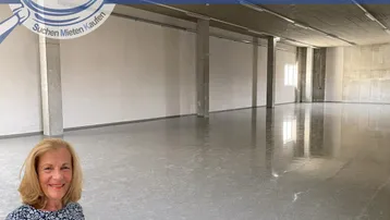 Großer, leerer Gewerberaum mit glänzendem Betonboden und tragenden Säulen, bereit zur individuellen Gestaltung.