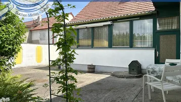 Terrasse mit Gartenmöbeln und Blick auf das Haus und die Umgebung.