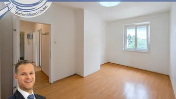 Helles, leeres Zimmer mit Parkettboden und Fenster, das viel Tageslicht hereinlässt.