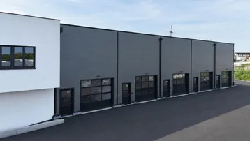 Moderne Gewerbegebäude mit mehreren Rolltoren und einer klaren, funktionalen Architektur.