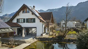 Charmantes Wohnhaus mit Solaranlagen, Naturteich und Bergblick in idyllischer Umgebung.