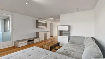 Geräumiges Wohnzimmer mit Holzboden, bequemer Couch und Blick auf die Umgebung.