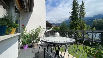 Balkon mit schmiedeeisernen Möbeln und malerischem Bergblick.