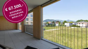 Geräumiger Balkon mit Fliesenboden und weitem Blick ins Grüne und auf die Berge.