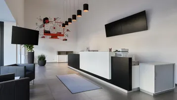 Moderner Empfangsbereich mit stilvoller Rezeption, bequemen Sitzgelegenheiten und dekorativer Wandkunst.