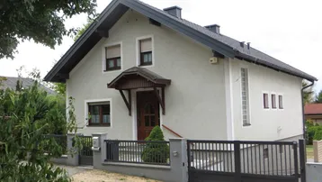 Vorderansicht des Einfamilienhauses mit Satteldach, Rollläden und einem gepflegten Vorgartenbereich.