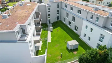 Moderne Wohnanlage mit begrünten Dächern, Balkonen und einem grünen Innenhof.