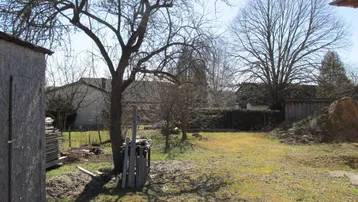 Großer Gartenbereich mit alten Bäumen und einem Schuppen, bereit für die Landschaftsgestaltung.