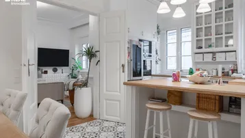 Offener Küchenbereich mit Holzarbeitsplatte und Blick in das angrenzende Wohnzimmer.