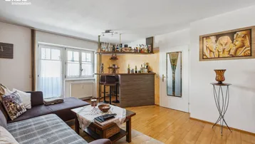 Gemütliches Wohnzimmer mit Holzboden, bequemer Couch und einer integrierten Bar für gesellige Abende.