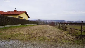 Weitläufiges Grundstück mit Blick auf die umliegende Landschaft und ein angrenzendes Wohnhaus.
