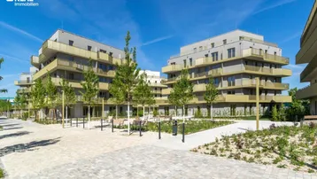 Moderne Wohngebäude mit ansprechenden Balkonen und einer gepflegten Grünanlage im Innenhof.