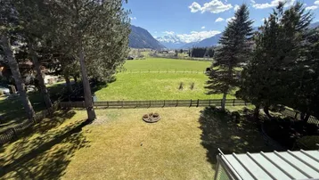 Weitläufiger Garten mit Rasenfläche und beeindruckendem Blick auf die umliegende Berglandschaft.
