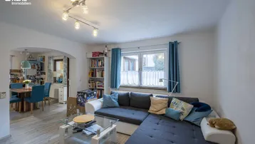 Gemütliches Wohnzimmer mit großem Ecksofa, Couchtisch und offenem Übergang zum Essbereich.