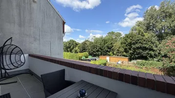 Gemütlicher Balkon mit Sitzgelegenheiten und Blick ins Grüne.