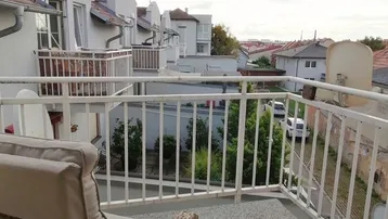 Möblierter Balkon mit Blick auf die umliegenden Gebäude und Dächer, ideal zum Entspannen.