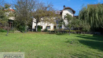 Großzügiger Gartenbereich mit Rasenfläche und altem Baumbestand vor dem Wohnhaus.