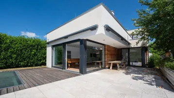 Großzügige Terrasse mit Steinplatten und Holzboden, ideal für entspannte Stunden im Freien.