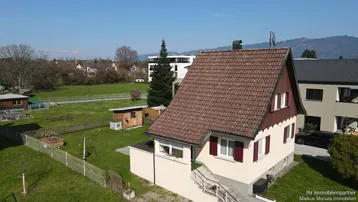 Luftaufnahme eines Einfamilienhauses mit Satteldach und großem Gartenbereich in ländlicher Umgebung.