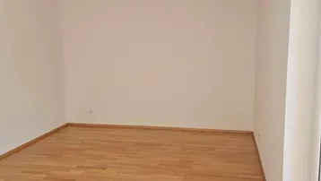Heller, leerer Raum mit hellem Holzboden und weißen Wänden, bereit zur individuellen Gestaltung.