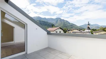 Geräumige Dachterrasse mit Fliesenboden und atemberaubendem Blick auf die umliegende Berglandschaft.