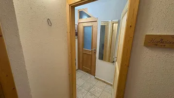 Flur mit Holztüren und Fliesenboden, der zu weiteren Räumen führt.