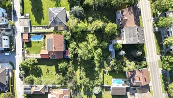 Luftaufnahme eines Wohngebiets mit Einfamilienhäusern, Gärten und Straßen.