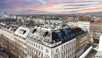 Panoramablick über die Stadt mit einem Gebäude mit Dachgeschosswohnungen und vielen Dachfenstern.