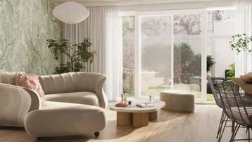 Helles Wohnzimmer mit beigem Sofa, Holzboden und direktem Zugang zum grünen Gartenbereich.