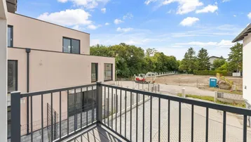 Blick vom Balkon auf die Umgebung mit weiteren Gebäuden und Baustelle.