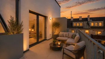 Geräumige Terrasse mit gemütlichen Sitzmöbeln und stimmungsvoller Beleuchtung bei Sonnenuntergang.