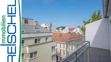 Heller Balkon mit Fliesenboden und Blick über die Dächer der Stadt an einem sonnigen Tag.