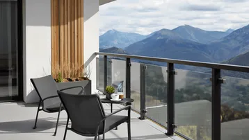 Moderner Balkon mit Sitzgelegenheiten und atemberaubendem Bergblick.