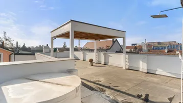 Große Dachterrasse mit Whirlpool, Pergola und weitem Blick über die Dächer der Stadt.