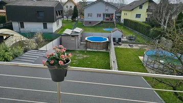 Weitläufiger Garten mit zwei Pools und Blick auf die umliegende Wohnbebauung.